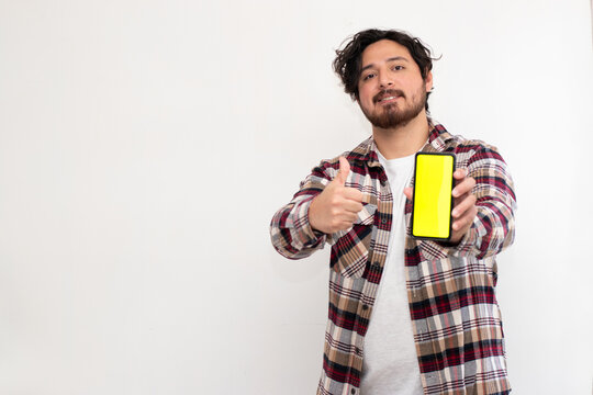 Hispanic man pointing cell phone with chroma key in vertical image in white background