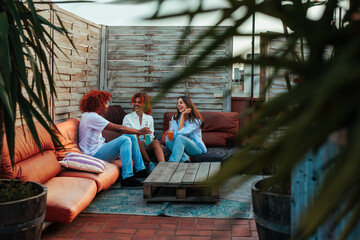 Three young people having fun conversation on rooftop