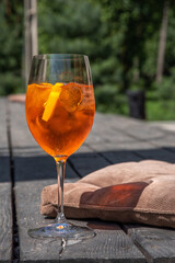 Girl drink iced alcohol Aperol spritz cocktail on summer terrace, in cafe or restaurant