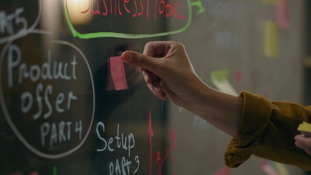 Healthcare, Middle-aged woman Concentratedly glues a sticker in a test center. Steady camera movement Young expert Works with data on a transparent wall Creating a drug development plan, industry
