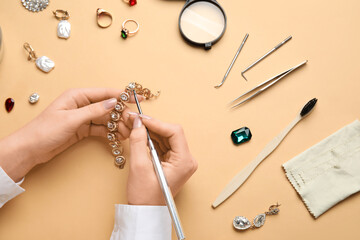 Woman cleaning beautiful accessories on color background, closeup