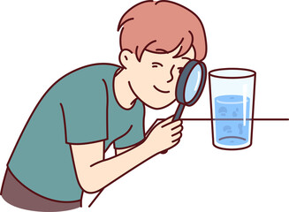 Small boy examines water in glass through magnifying glass, studying chemical composition liquid