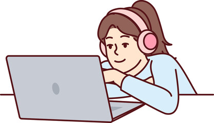 Little girl in headphones uses laptop watching children series or internet show for schoolchildren