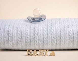 Fototapeta na wymiar baby boy clothes on rope,blue blanket bow and bodysuit,dry cotton.word baby from wooden letters,baby shower or its a girl.toddler infant booties knitted pattern.eco blocks.ultrasound picture of fetus.