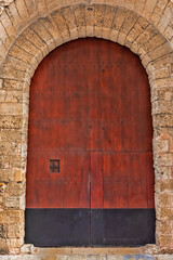 Fototapeta na wymiar Exterior of Large Old Wooden Arched Door in Spain