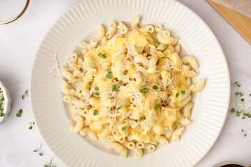 Plate of tasty Italian pasta with Cheddar cheese on light background