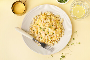 Plate of tasty Italian pasta with Cheddar cheese on yellow background