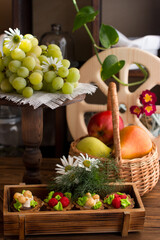 Cakes and fruits in a wicker basket on a wooden background. The concept of a vintage-style store