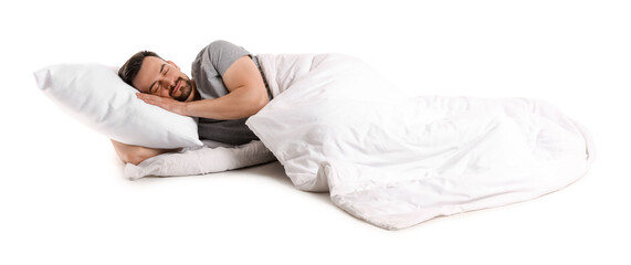 Handsome man with pillow and soft blanket lying on white background