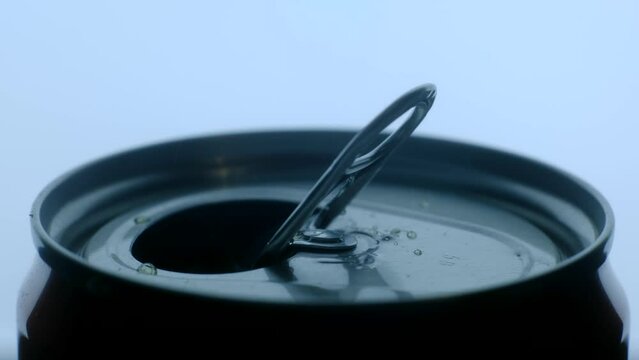 Opening soda or beer can macro close up of can pull tab, hand open lemonade, refreshment. High quality 4k footage. With my fingers I open a tin can with a drink in the background light close-up