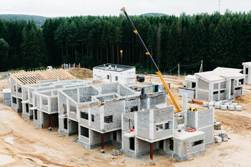 Fototapeta premium Modern townhouses in a residential area with multiple new apartments buildings surrounded by green outdoor facilities in central calm neighborhood