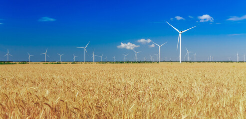 Wind turbines generating electricity on field. Eco power, ecology and alternate power concept.