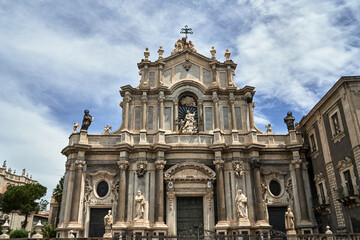 Fototapeta na wymiar Columns and statues of the Baroque facade of the Cathedral Basilica of St. Agates in the city of Catania