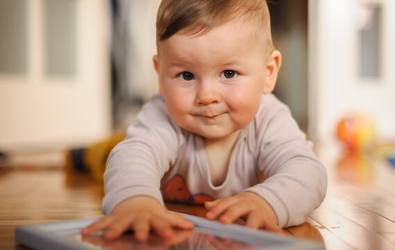 Cute baby boy crawls on the home floor, explore the world and learn to move. Love and family emotion
