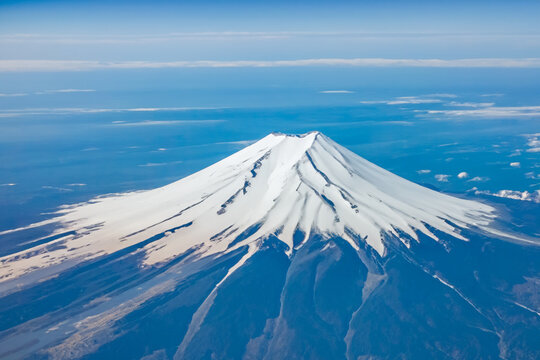 Top view of the Japan icon Mt Fuji from the airplane. Mt. Fuji seen from the window of an airplane. bird eye view of fuji mountain, famous volcano in japan, shot from airplane window.