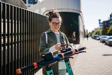 Young woman in city lending scooter with application.