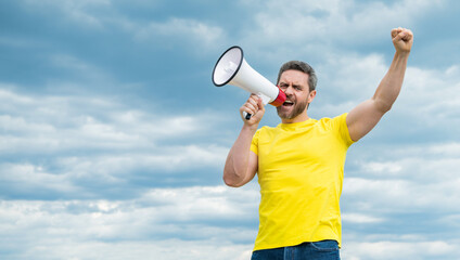 man in yellow shirt shout in megaphone on sky background. attention