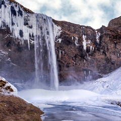 Iceland waterfall in winter with ice and snow