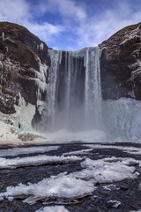 Iceland waterfall in winter with ice and snow
