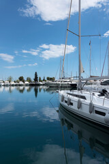 Modern yacht moored in marina and calm water with reflection. Vacation and tourism concept 