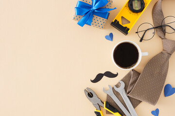 Celebrate Father's Day concept. Top view flat lay of cup of coffee, hand tools, men's accessories, gift box, blue hearts on pastel beige background with empty space for text or advert