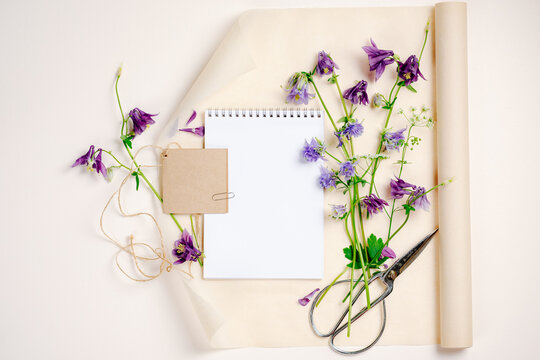 Aquilegia flowers, notebook blank mockup, top view, copy space.