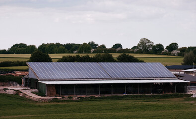 Warehouse with solar panels on the roof. Nature-produced energy. Sun-produced energy. Photovoltaic systems on the barn house in the countryside. Semiconductor technology. Carbonless footprint. © I am from Mykolayiv