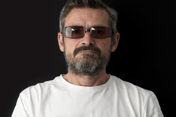 Portrait of aged  beard man in sunglasses close up on black background