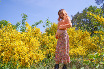 Close-up of young pregnant woman touching her belly and caring about her health.Pregnancy, maternity, preparation and expectation concept.Beautiful tender mood photo of pregnant woman.Young mom.
