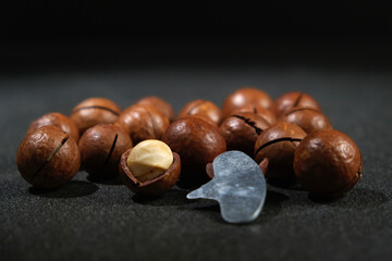 Macadamia nuts with a key on a black background.