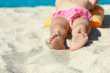 Fototapeta na wymiar A feet of a happy child near the seashore in nature weekend travel