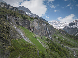 Obraz premium Sommer in den Alpen mit grünen Wiesen, Wasserfällen und Gletschern