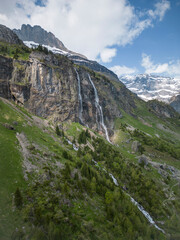 Sommer in den Alpen mit Wiesen, Wasserfällen und Gletschern
