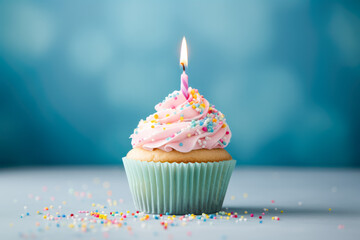 Birthday cupcake with candle against blue background.