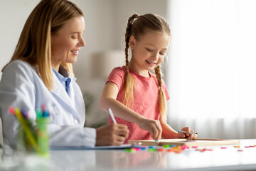 Little Girl Painting On Draw Board During Meeting With Child Development Specialist