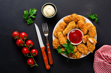 Delicious Crispy Fried Breaded Chicken Breast Strips with Ketchup on Dark Background