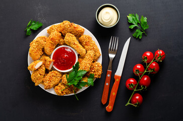 Delicious Crispy Fried Breaded Chicken Breast Strips with Ketchup on Dark Background