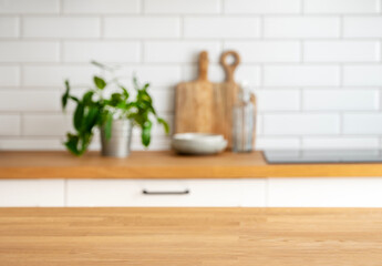 Wooden tabletop with free space for product montage or mockup against blurred white kitchen with...