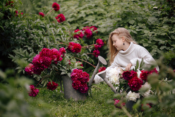 a girl in a flower garden of peonies