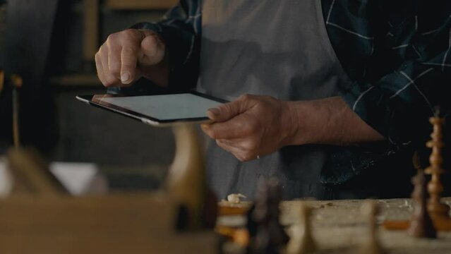 Timber, Business owners Works with an electronic tablet looks at the screen In a furniture workshop Woodworking technician Works with wood blanks In a craftsman's workshop, small business
 - Powered by Adobe