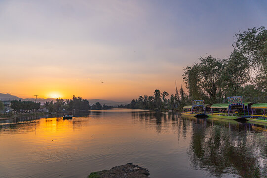Hermoso atardecer en el lago de Xochimilco, trajineras de fondo. 