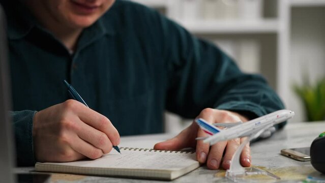 Wanderlust, Young active man In a good mood Writes travel plans in a diary In a conference room, Close-up Nature lover Prepares to go on exploration Refresh his inner state of mind, wanderer
