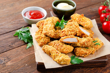 Delicious Crispy Fried Breaded Chicken Breast Strips with Ketchup on Dark Background