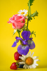 Chaotic bouquet with strawberries in Kenzan on a yellow  background