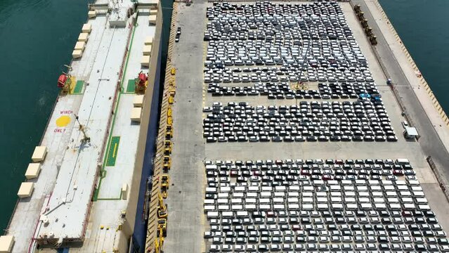 Aerial drone pan video of large car carrier ro ro vessel anchored to Mediterranean Automobile loading - unloading terminal port