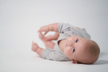 portrait of a baby in gray clothes. photography on a light background