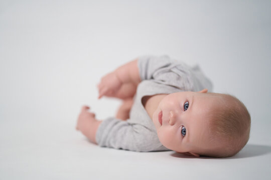 portrait of a baby in gray clothes. photography on a light background