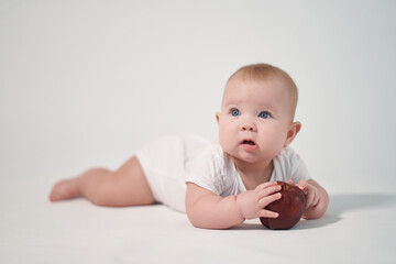Newborn baby with red apple on white background