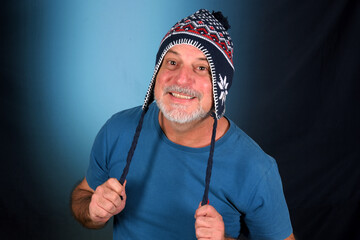 happy bald man with white beard Peruvian cap on his head looking forward with good expression