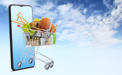 Shopping cart filled with gardening equipment emerges from smartphone, isolated on sky background,...